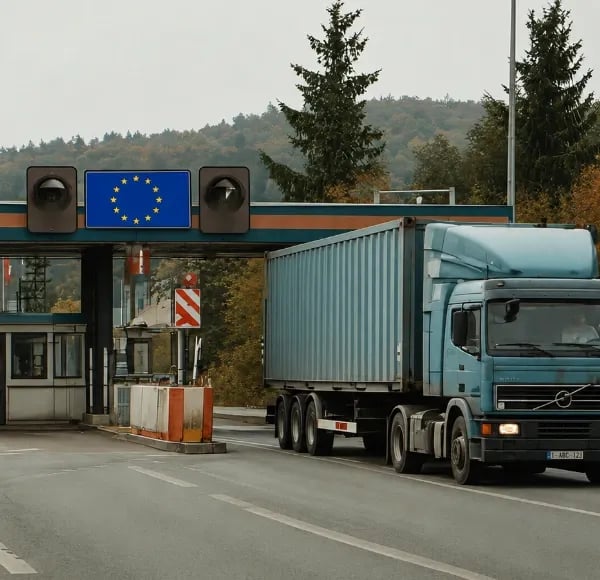Photo de camion à un poste douanier, avec un panneau représentant le drapeau de l'Europe